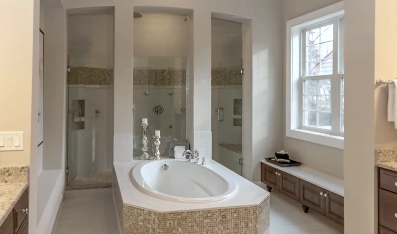 Primary bathroom with a soaking tub, glass-door showers, mosaic tile and a window seat