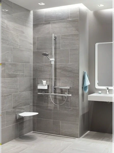 Gray stone-look tile shower with a fold-down seat, a slide-bar handheld shower and a wall-hung sink