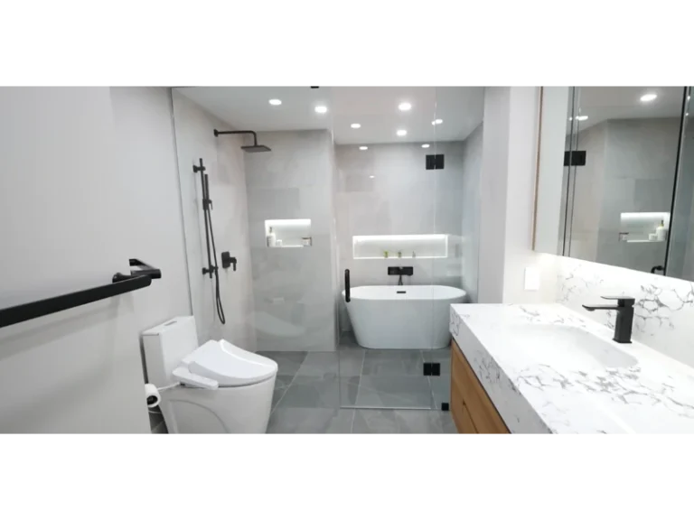 Remodeled bathroom with a glass walk-in shower, freestanding white tub, black fixtures and a floating wood vanity with marble-look top