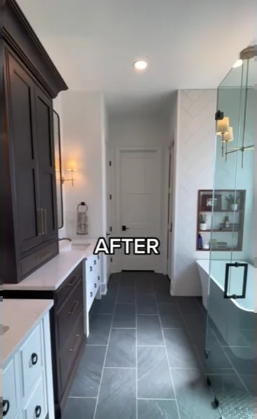 Primary bathroom with dark slate-look floor tile, dark wood cabinetry and a glass shower